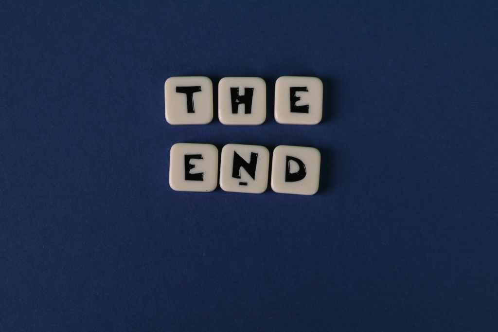 scrabble tiles forming the words the end on blue background