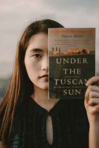 woman holding under the tuscan sun book